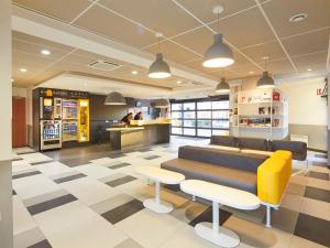 a lobby of a store with a couch and chairs at Première Classe Marne la Vallée - Bussy Saint Georges in Bussy-Saint-Georges