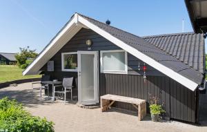 a black shed with a white roof and a table at Awesome Home In Hejls With Wifi in Hejls +10 photos