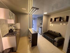 a small kitchen with a stove and a couch in it at hermoso apt en pereira in Pereira