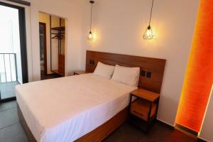 a bedroom with a large bed and two lights at Palmas Luxury Apartment 103 in Oaxaca City