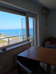 Una habitación con una mesa y vista al mar. en Maria Residence 12A Costinesti, en Mangalia
