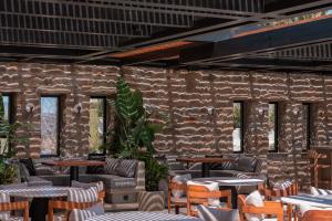 a restaurant with tables and chairs and a stone wall at Noir Mykonos in Mikonos
