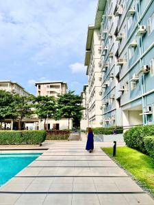 a woman in a blue dress standing next to a building at Khyzer's Place in Quezon City