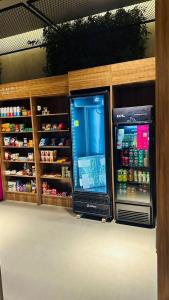 two refrigerators in a store with food and drinks at LG1308 - Studio moderno | ao lado Metrô Santa Cruz in Sao Paulo