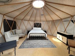 FredericksburgGlampanee - off grid SITE 2的蒙古包内一间卧室,配有一张床和一张沙发