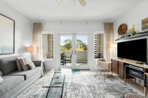 a living room with a couch and a flat screen tv at 30A - Cassine Station by Panhandle Getaways in Santa Rosa Beach