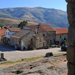 a group of stone buildings with mountains in the background at Rustic Terrace2 Bedrooms Farm House in Mesquitela