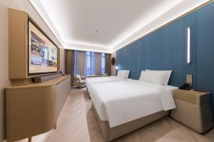 Voodi või voodid majutusasutuse Tianjin Station Crystal Orange Hotel toas