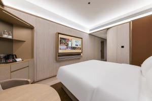 Voodi või voodid majutusasutuse Tianjin Station Crystal Orange Hotel toas