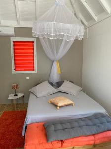 a bedroom with a large bed with a canopy at Logement entier, Bungalow ou T2 in Sainte-Rose