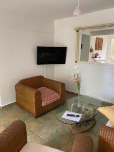 a living room with a couch and a glass table at Logement entier, Bungalow ou T2 in Sainte-Rose