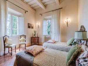 two beds in a room with two windows at Villa in Cetona close to Rome in Cetona +110 photos