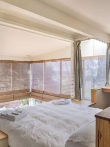 a bedroom with a large bed with a large window at One Hundred Banksias in Culburra Beach