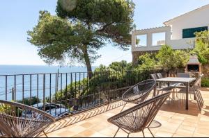 a patio with a table and chairs and the ocean at "Terrasse de la Mer 1" Résidence"Sol y Mar" AC-Wifi-BBQ-Piscine-Pkg in Begur