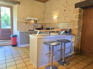una cucina con due sgabelli da bar a bancone di Charmante maison périgourdine avec jardin, cheminée, Wifi et équipements bébé, proche de Sarlat - FR-1-616-130 a Saint-André-dʼAllas Altre 5 foto