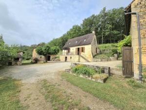 une ancienne maison en pierre sur un chemin de terre dans l'établissement Maison à Aubas: 2 chambres, animaux admis, parking - FR-1-616-185, à Aubas
