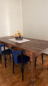a wooden table with two chairs and a bowl of fruit at Apart 202 - Centro Histórico in Itu