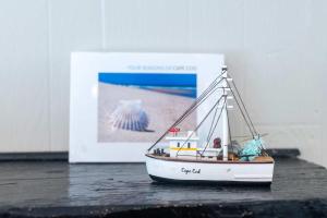 a small toy boat sitting on a table next to a picture at Family Yarmouth Beach Resort 3BR Getaway in Yarmouth
