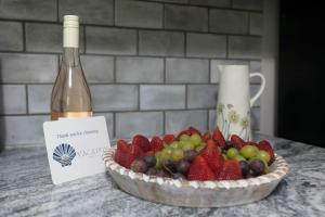 a bowl of fruit next to a bottle of wine at Family Yarmouth Beach Resort 3BR Getaway in Yarmouth