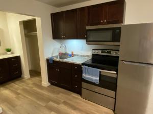 a kitchen with stainless steel appliances and wooden cabinets at Green River Inn Apartments in Green River +13 photos