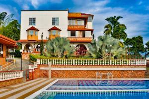 a house with a swimming pool in front of a house at Casa Nova Hotel campestre in Circasia