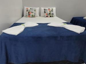 a bed with two white towels on top of it at Quarto suíte 8, cama casal1, cama solteiro 1 in Marabá
