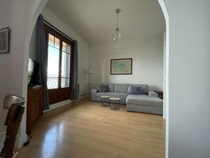 ein Wohnzimmer mit Sofa und Tisch in der Unterkunft Appartement moderne près des thermes avec balcon et animaux admis - FR-1-498-68 in Évian-les-Bains