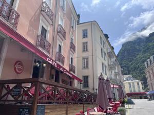 a group of buildings with tables and umbrellas on a street at Appartement central à Cauterets, idéal pour 5 pers, animaux admis - FR-1-812-137 in Cauterets
