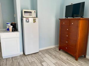a refrigerator with a microwave on top of it next to a dresser at Beachgate Condo Suites and Hotel 512AB condo in Port Aransas