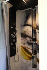 Un baño con ducha con un cuadro en la pared. en Happy Spiritus Apartment, en Tabanan