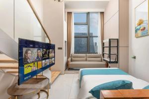Camera con letto e TV a schermo piatto. di 深圳华尔曼欢朋酒店公寓 罗湖水贝珠 宝城店 a Shenzhen
