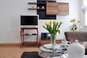 a living room with a television and a vase of flowers at Ferienwohnung am Park FeWo2 in Gotha