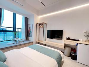 una camera da letto con un letto grande e una grande finestra di 深圳华尔曼欢朋酒店公寓 罗湖水贝珠 宝城店 a Shenzhen