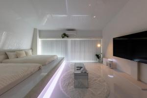 ein Schlafzimmer mit zwei Betten und einem Flachbildfernseher in der Unterkunft AMP FLAT Daimyo 702 in Susakiuramachi