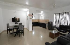 a living room with a table and a couch at Maria villa in Ooty