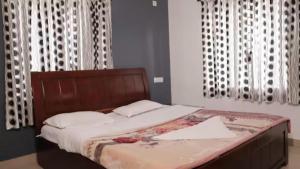 a bed with a wooden headboard in a bedroom at Maria villa in Ooty