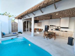 a kitchen and a swimming pool in a house at Villa Vinodayan Uluwatu by LODGELINK BALI in Uluwatu