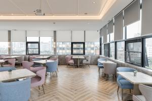 a restaurant with tables and chairs and windows at Atour Hotel Chengdu Kuanzhai Alley in Chengdu