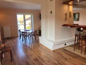 a kitchen and dining room with a table and chairs at Jūrlejas in Kaltene