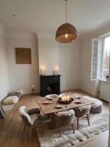 ein Wohnzimmer mit Tisch und Kamin in der Unterkunft La Folie Giverny - Villa Premium - 3 Suites VIP - 8 Pièces 150M2- Centre Village - Maison privatisée -Jardin paysagé - Parking- in Giverny