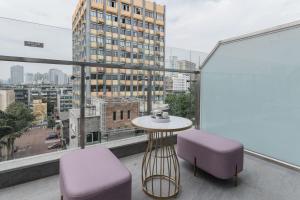 a balcony with a table and two chairs and a window at Atour Hotel Chengdu Kuanzhai Alley in Chengdu