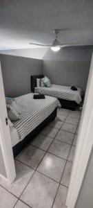 two beds sitting in a room with a tiled floor at LaMouette 8 Manaba Beach Uvongo in Margate