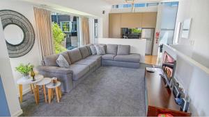 a living room with a couch and a tv at The Alps Apartment Three Bedroom in Queenstown