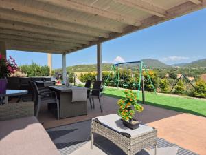 a patio with tables and chairs and a view at Villa Criade in Castelsardo