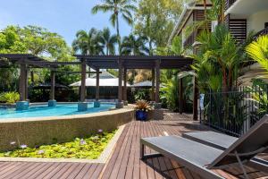 Un patio con piscina al lado de una casa. en 21 Freestyle Apartment with POOL VIEW, en Port Douglas