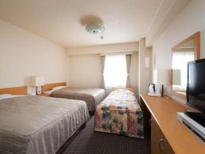 a hotel room with two beds and a flat screen tv at Sapporo Hotel Yamachi in Kotoni +58 photos