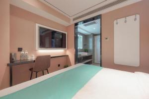 a bedroom with a bed and a chair and a sink at Xana Lite Beijing Sidaokou Dazhong Temple Metro Station Branch in Beijing