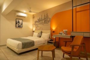 a hotel room with a bed and a desk at Hotel City Pride in Mahuva