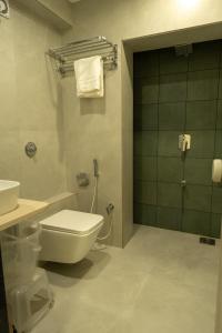 a bathroom with a toilet and a shower and a sink at Hotel City Pride in Mahuva
