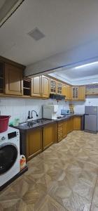 a kitchen with wooden cabinets and a white appliance at HomeS7 Shah Alam in Shah Alam +15 photos